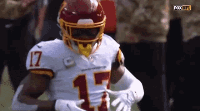 a football player with the number 17 on his jersey is running on the field