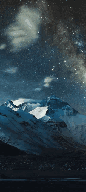 a mountain covered in snow with a starry sky behind it