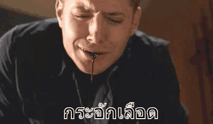 a man with blood coming out of his mouth and a foreign language written on the bottom .