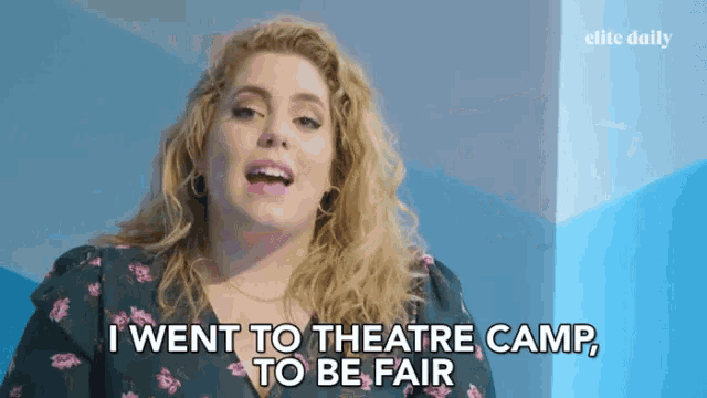 a woman says " i went to theatre camp to be fair " in front of an elite daily ad