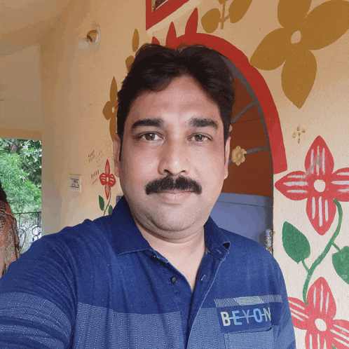 a man wearing a blue shirt with the word bey-on on the pocket