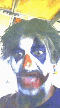 a man with his face painted like the joker looks at the camera