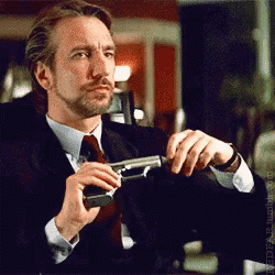 a man in a suit and tie is holding a gun in his hand