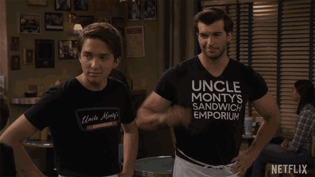 two men wearing shirts that say uncle monty 's sandwich emporium stand next to each other