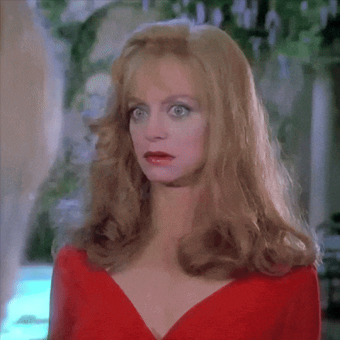 a woman in a red dress is looking at the camera with a surprised look on her face