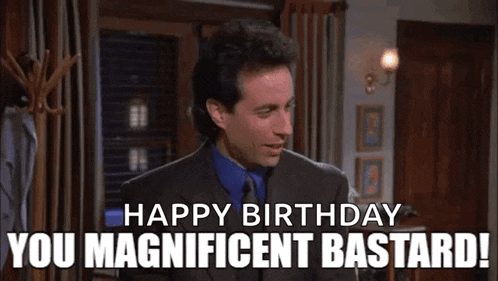 a man in a suit and tie is standing in a room and saying `` happy birthday you magnificent bastard ! ''