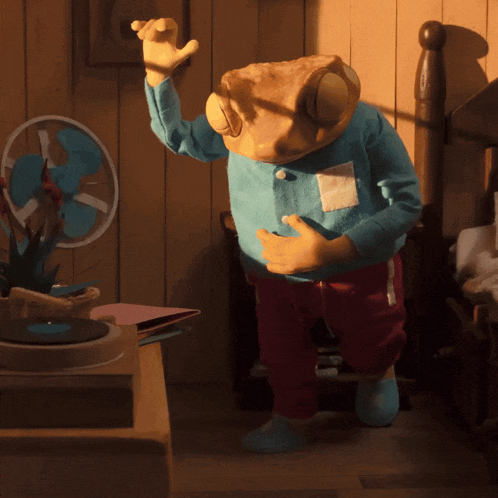 a stuffed animal with a frog head is dancing in a room