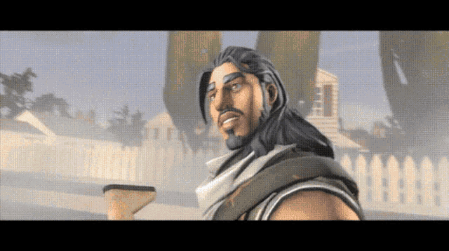 a man with long hair and a beard is standing in front of a fence