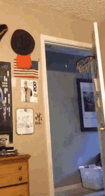 a room with a basketball hoop hanging on the wall and a dresser
