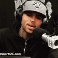 a man wearing headphones is talking into a microphone .