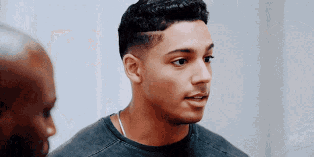 a close up of a man 's face with a man behind him
