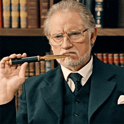 a man in a suit holds a pen in his mouth