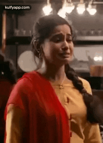 a woman in a yellow top and red dupatta is crying .