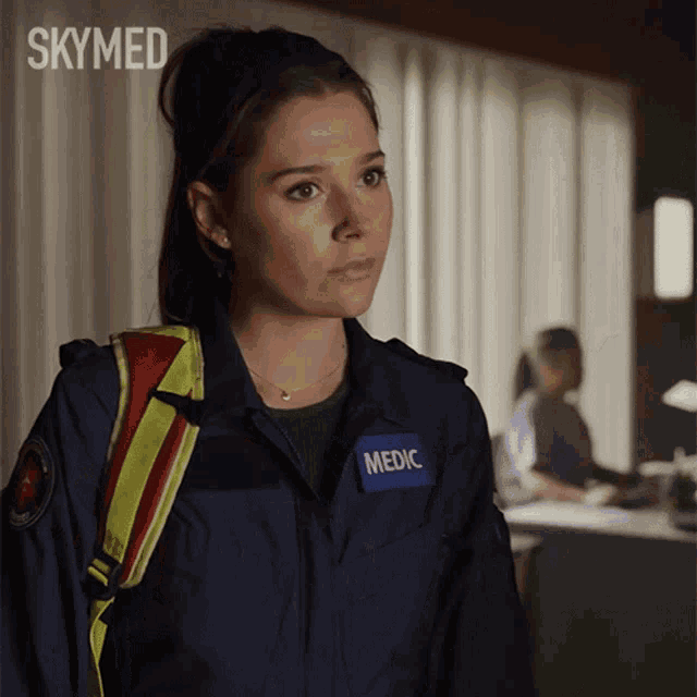 a woman wearing a blue jacket with the word medic on her chest