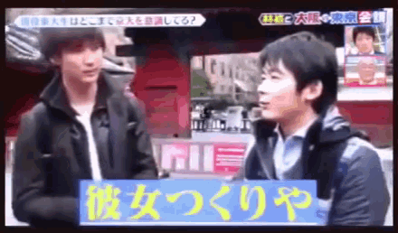 two men are standing next to each other on a television screen with japanese writing