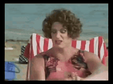 a woman in a wig is sitting in a beach chair .