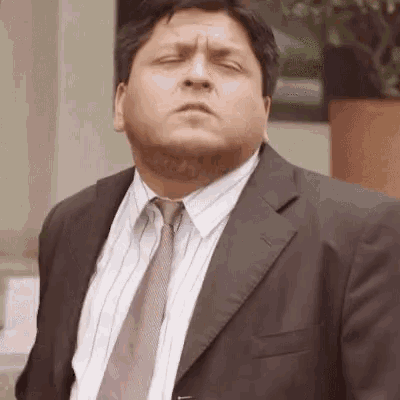 a man in a suit and tie is looking at the camera