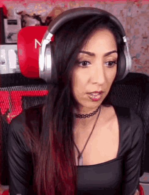 a woman wearing headphones and a choker with the letter n on it