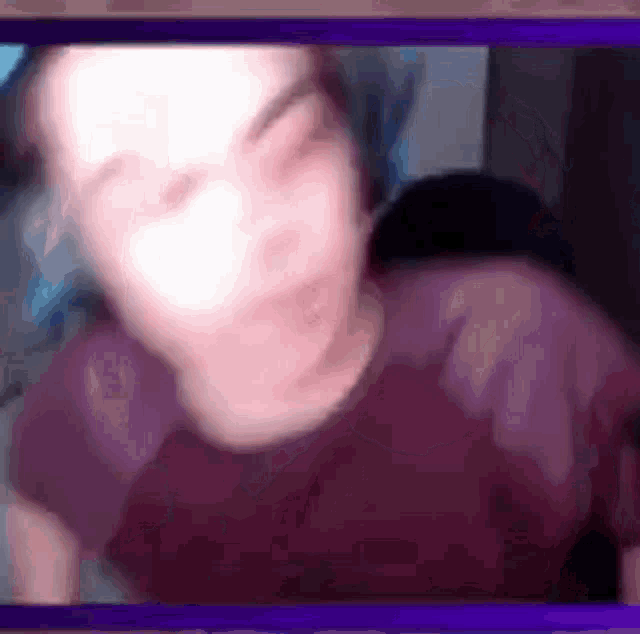 a blurry picture of a person 's face on a purple screen .