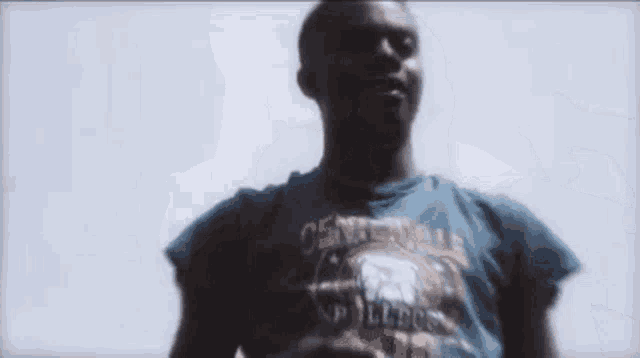 a man wearing a blue shirt with the word nation on it shows off his muscles