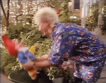 a woman in a blue shirt is holding a stuffed animal in her hands .