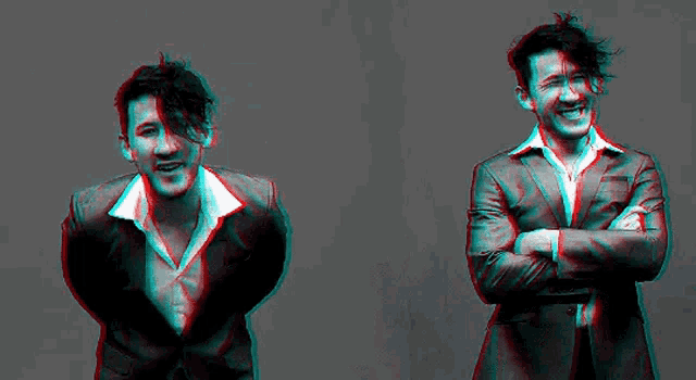 two men in suits are standing next to each other with their arms crossed and looking up .