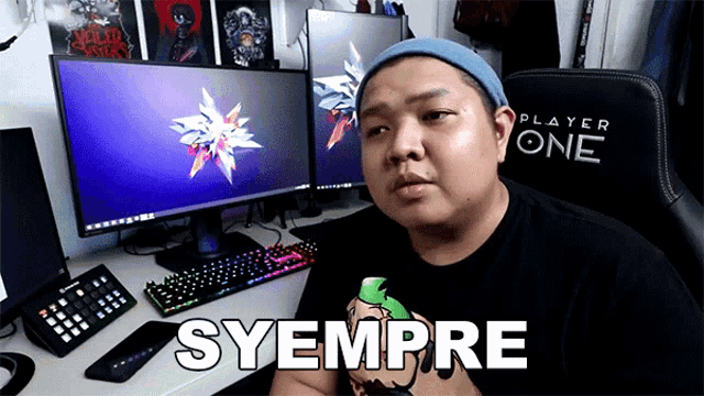 a man sitting in front of a computer with the word syempre on his shirt