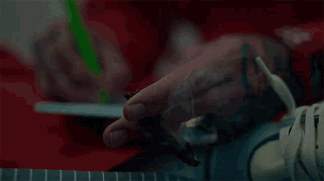 a close up of a person smoking a cigarette and writing on a piece of paper