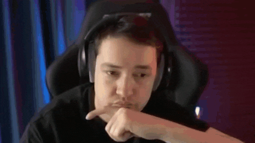 a man wearing headphones is sitting in a chair and making a funny face .