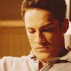 a close up of a man 's face looking down with his eyes closed
