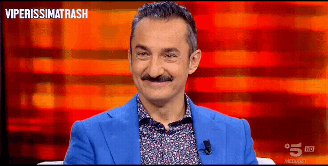 a man in a blue suit is smiling in front of a red background with the words viperissimorash
