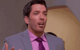 a man in a suit and tie is standing in a room .