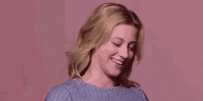 a close up of a woman wearing a blue sweater smiling .