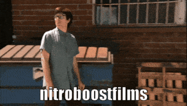 a man is standing in front of a brick wall with the words nitroboostfilms on the bottom