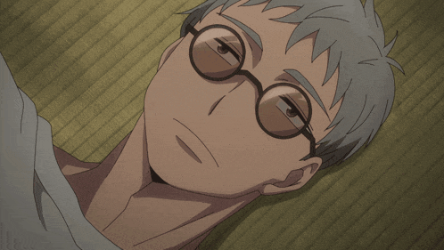 a man wearing glasses is laying down on a mat