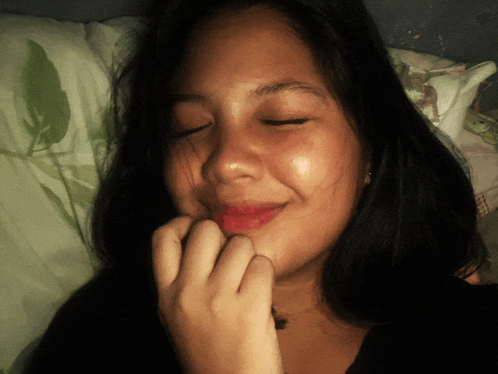a young woman with her eyes closed and her hand on her chin