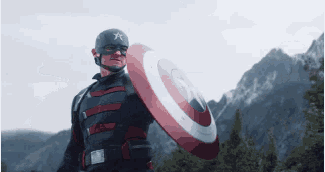 a man in a captain america uniform holds a shield in front of a mountain