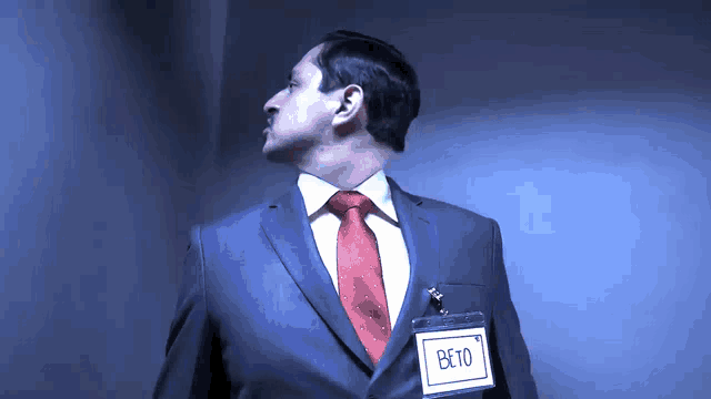 a man in a suit and tie has a name tag that says beto on it