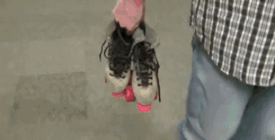 a person holding a pair of roller skates in their hand .