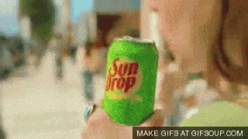 a person holding a green can of sun drop
