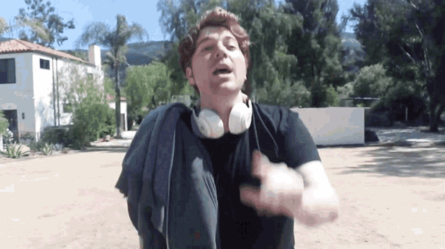 a man wearing headphones is standing in a field