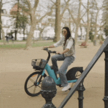 a woman is riding a bicycle in a park