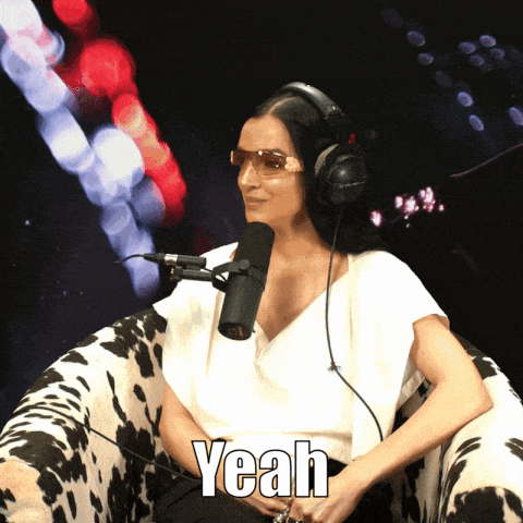 a woman wearing headphones and sunglasses is sitting in front of a microphone and the word yeah is on the bottom