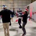 a group of people wearing santa hats are dancing together