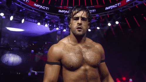 a shirtless wrestler stands in front of a sign that says impact on it