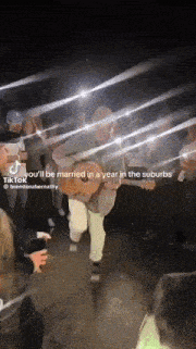 a man playing a guitar in front of a crowd with a caption that says you 'll be married