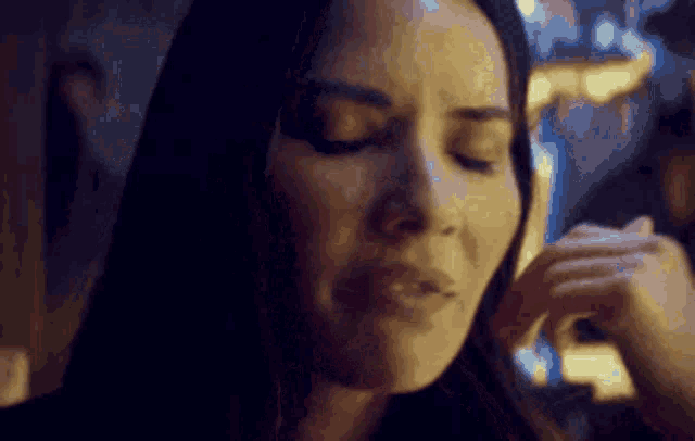 a close up of a woman with her eyes closed .