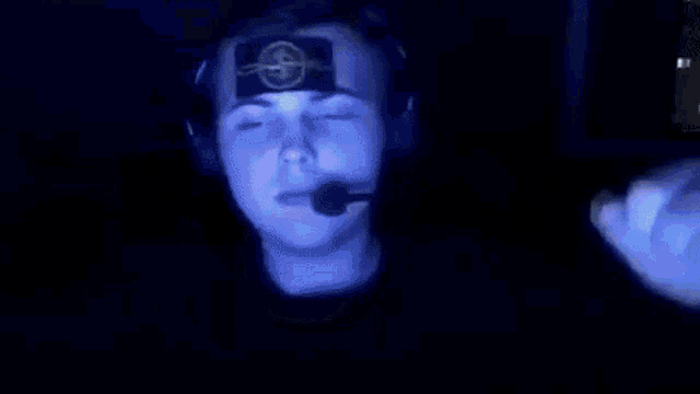 a man wearing headphones and a microphone has a picture of a cat on his face .