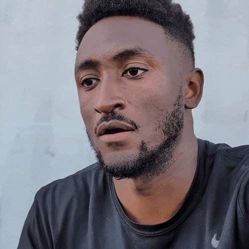 a man with a beard is wearing a black nike t-shirt