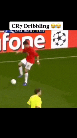 a soccer player dribbles a ball in front of a fone sign